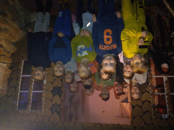 Zdjęcie przedstawia uczniów stojących na tle ściany z pierników   