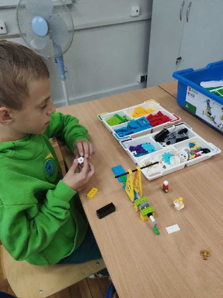 uczeń układa konstrukcję z klocków lego